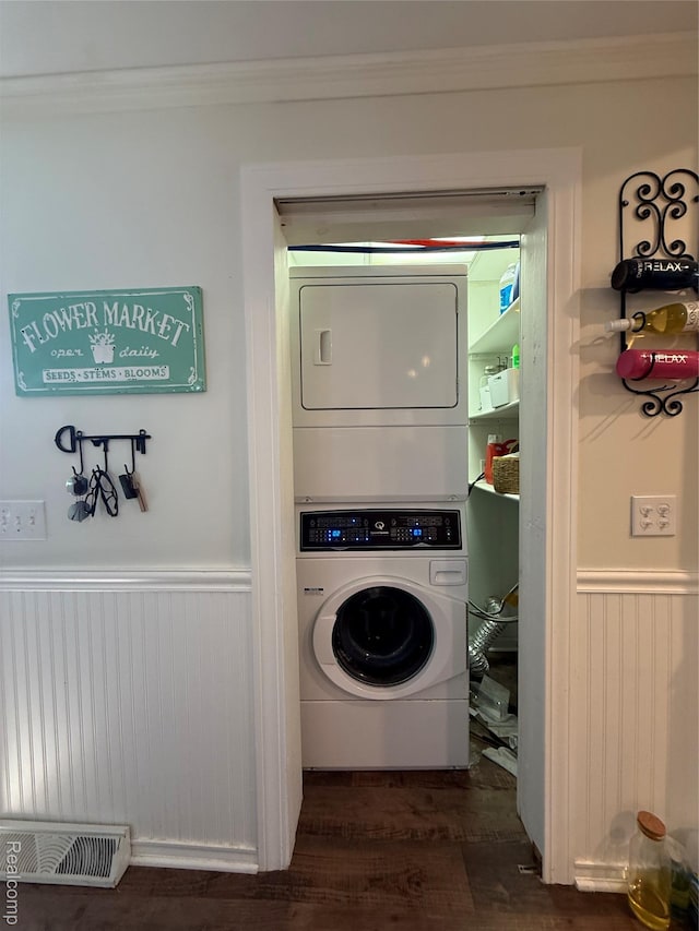 18 Park St, Oxford, MI 48371 - laundry room with stacked washer / drying machine, crown molding, wainscoting, dark wood-style flooring, and wooden walls