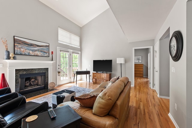 6018 Augusta Ct, Grand Blanc, MI 48439 - living room featuring high vaulted ceiling, light wood-type flooring, a premium fireplace, and baseboards