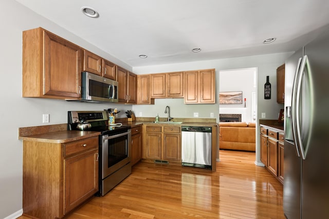 6018 Augusta Ct, Grand Blanc, MI 48439 - kitchen with stainless steel appliances, a sink, dark countertops, light wood finished floors, and recessed lighting