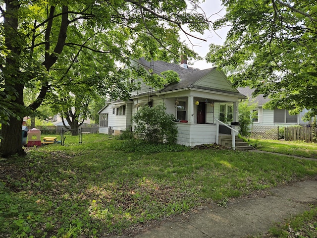804 17th St, Jackson, MI 49203 - view of front of home with a chimney, a porch, and roof with shingles