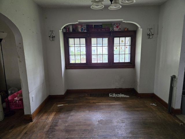 804 17th St, Jackson, MI 49203 - unfurnished dining area with arched walkways, hardwood / wood-style floors, baseboards, and a chandelier