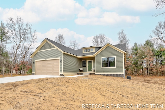 408 Sabine Dr Unit 10, Muskegon, MI 49442 - view of front facade with concrete driveway, an attached garage, central AC, and a shingled roof