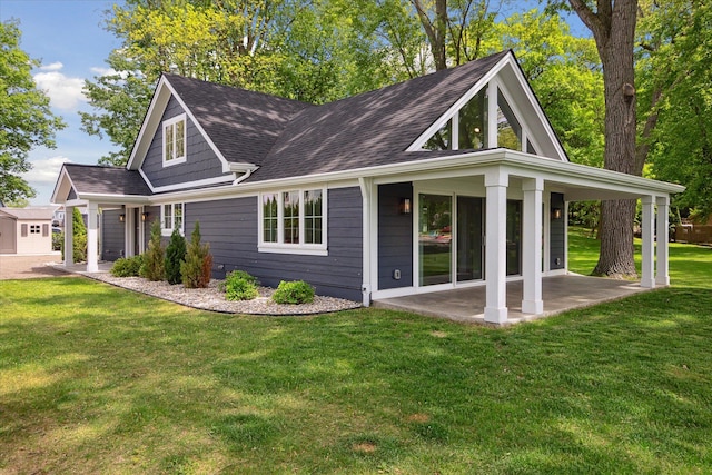5150 Redding Dr, Pinckney, MI 48169 - rear view of property featuring a lawn, a shingled roof, and a patio