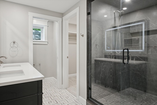 5150 Redding Dr, Pinckney, MI 48169 - bathroom featuring a stall shower, double vanity, a spacious closet, and baseboards