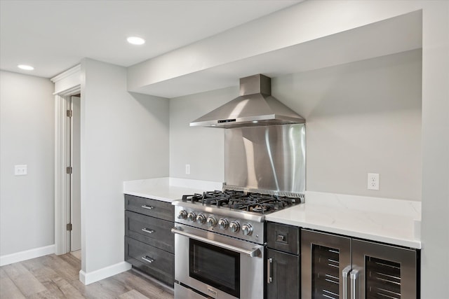 5150 Redding Dr, Pinckney, MI 48169 - kitchen with wall chimney exhaust hood, beverage cooler, high end stainless steel range, light wood finished floors, and baseboards