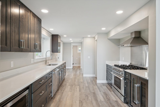 5150 Redding Dr, Pinckney, MI 48169 - kitchen featuring wall chimney exhaust hood, a sink, appliances with stainless steel finishes, dark brown cabinetry, and recessed lighting