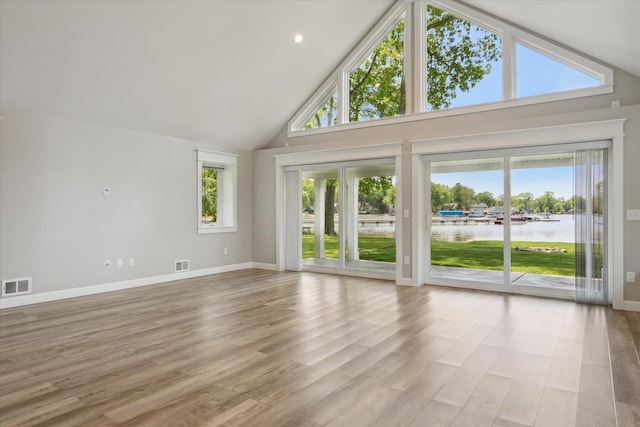 5150 Redding Dr, Pinckney, MI 48169 - unfurnished living room with a water view, high vaulted ceiling, baseboards, and wood finished floors