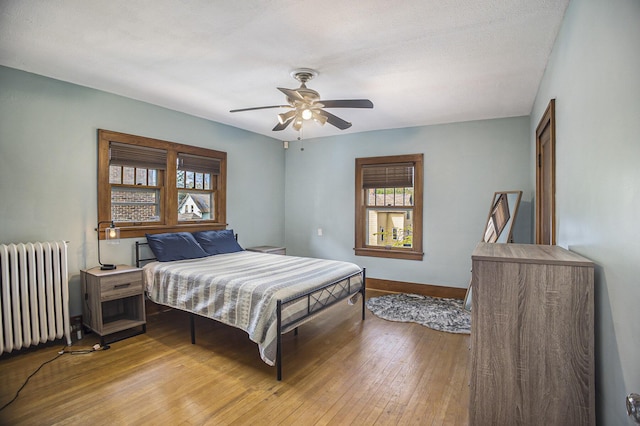 2046 Bourdon St, Muskegon, MI 49441 - bedroom with radiator, light wood-style flooring, baseboards, and a ceiling fan