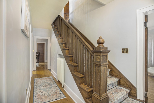 2046 Bourdon St, Muskegon, MI 49441 - stairway featuring wood finished floors, baseboards, and radiator