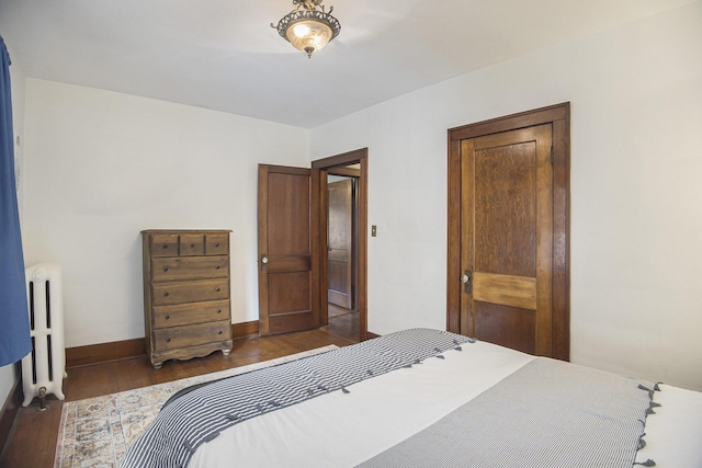 2046 Bourdon St, Muskegon, MI 49441 - bedroom with radiator, dark wood-style floors, and baseboards