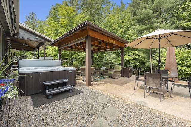 6838 E Michillinda Rd, Twin Lake, MI 49457 - view of patio featuring a hot tub, a gazebo, an outdoor hangout area, outdoor dining area, and view of wooded area