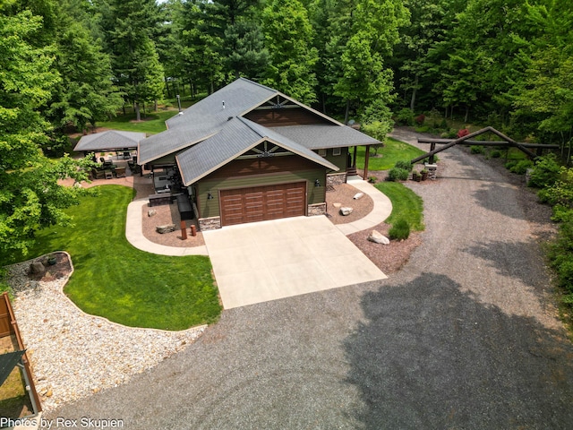 6838 E Michillinda Rd, Twin Lake, MI 49457 - view of front of property featuring concrete driveway, stone siding, a garage, a front yard, and a view of trees