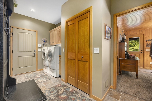 6838 E Michillinda Rd, Twin Lake, MI 49457 - washroom featuring washing machine and clothes dryer, cabinet space, light stone finish floors, baseboards, and wood walls