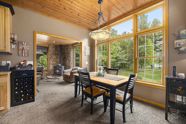 6838 E Michillinda Rd, Twin Lake, MI 49457 - dining space featuring a wood stove, wood ceiling, carpet flooring, plenty of natural light, and crown molding