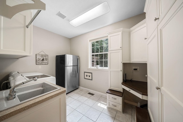 33081 Old Post Rd, Niles, MI 49120 - kitchen with freestanding refrigerator, light tile patterned floors, white cabinets, a sink, and baseboards