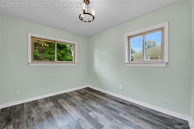 6927 Snow Apple Dr, Clarkston, MI 48346 - spare room featuring healthy amount of natural light, a chandelier, dark wood-style flooring, and baseboards