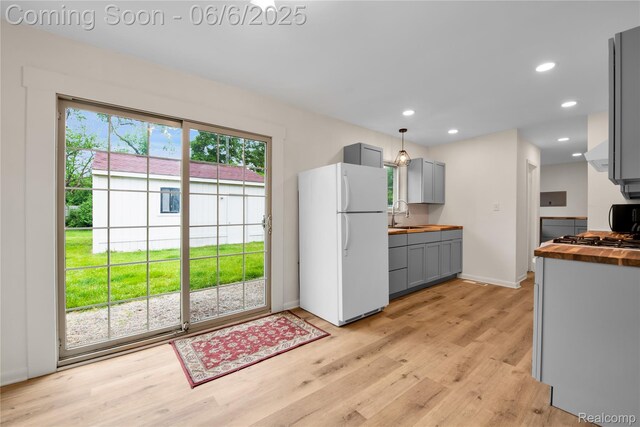 6927 Snow Apple Dr, Clarkston, MI 48346 - kitchen with freestanding refrigerator, butcher block counters, gray cabinets, a sink, and light wood-type flooring