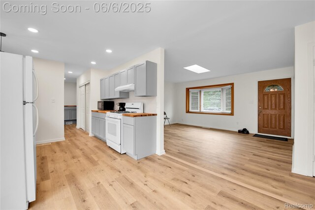 6927 Snow Apple Dr, Clarkston, MI 48346 - kitchen with white appliances, light wood-style floors, under cabinet range hood, baseboards, and recessed lighting