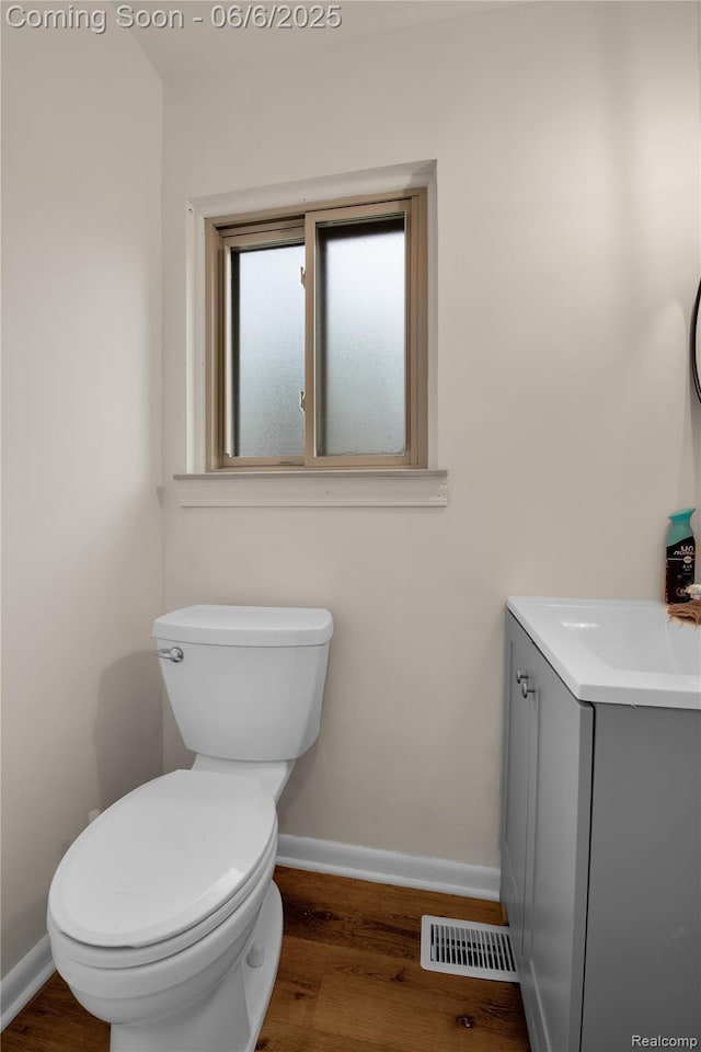 6927 Snow Apple Dr, Clarkston, MI 48346 - bathroom with vanity, toilet, wood finished floors, and baseboards