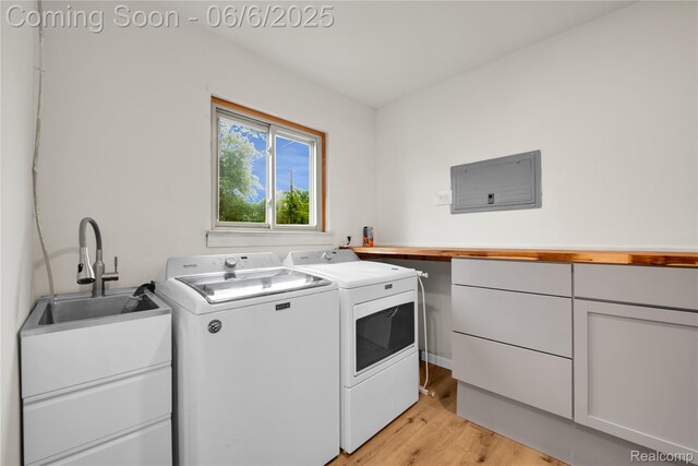 6927 Snow Apple Dr, Clarkston, MI 48346 - laundry room with separate washer and dryer, light wood-type flooring, and cabinet space