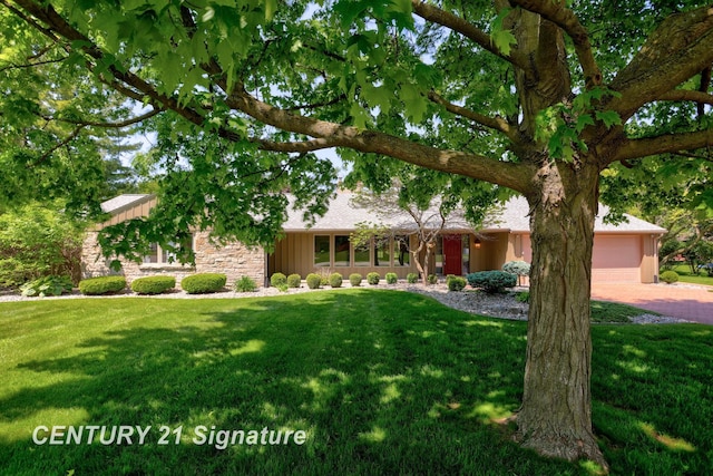 12 W Corral Dr, Saginaw, MI 48638 - view of front of home featuring board and batten siding, a front lawn, decorative driveway, and stone siding
