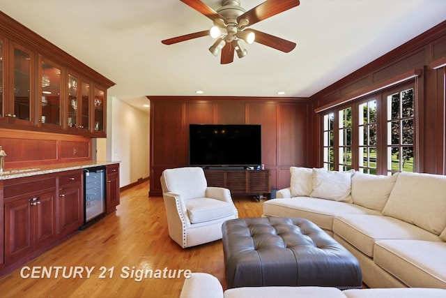 12 W Corral Dr, Saginaw, MI 48638 - living room featuring beverage cooler, light wood finished floors, a ceiling fan, and baseboards