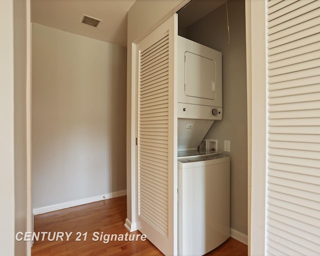 12 W Corral Dr, Saginaw, MI 48638 - laundry room with stacked washer and clothes dryer, wood finished floors, and baseboards