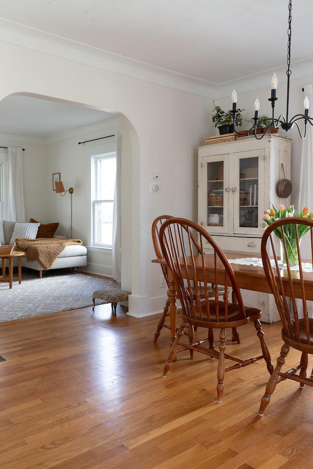 1550 Pine Ave NW, Grand Rapids, MI 49504 - dining area with arched walkways, ornamental molding, and light wood-type flooring