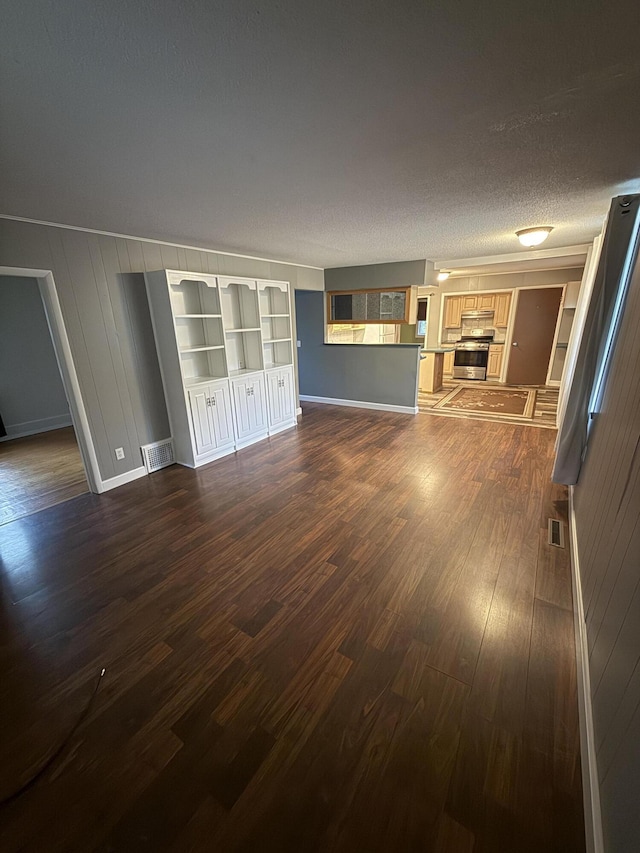 106 S Berkley St, Kalamazoo, MI 49006 - unfurnished living room featuring dark wood finished floors, baseboards, a textured ceiling, and built in features