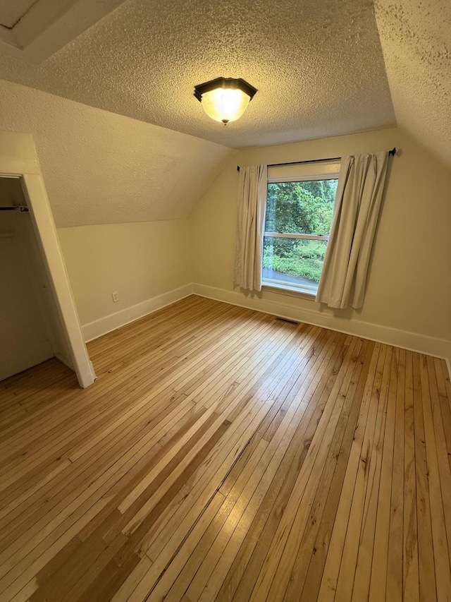106 S Berkley St, Kalamazoo, MI 49006 - additional living space featuring a textured ceiling, lofted ceiling, light wood-style flooring, and baseboards