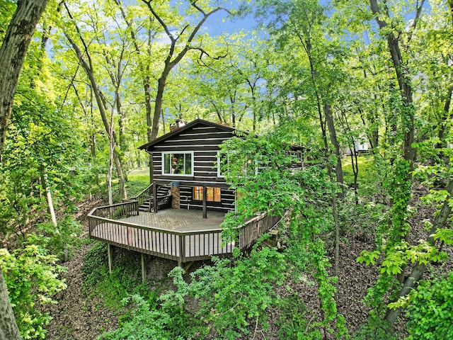 8721 Onandaga Rd, Clarkston, MI 48348 - back of property featuring a deck, log veneer siding, and a chimney