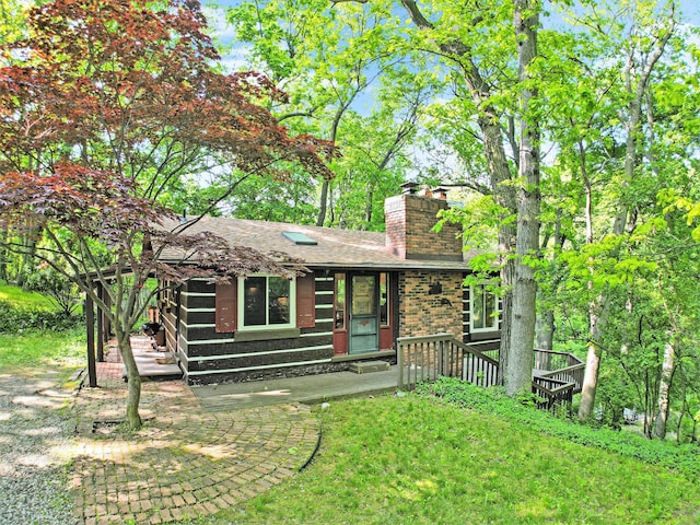 8721 Onandaga Rd, Clarkston, MI 48348 - rear view of house with a chimney, brick siding, and roof with shingles