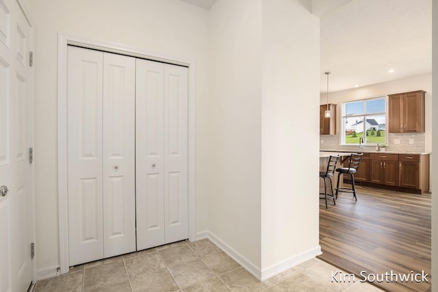 12285 Apple Cart Ln, Lowell, MI 49331 - hallway featuring baseboards, light tile patterned floors, recessed lighting, and a sink