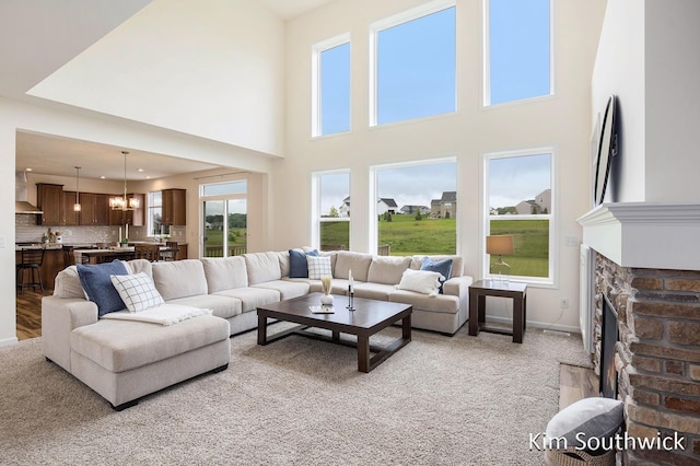 12285 Apple Cart Ln, Lowell, MI 49331 - living room featuring healthy amount of natural light, light carpet, a stone fireplace, and a towering ceiling
