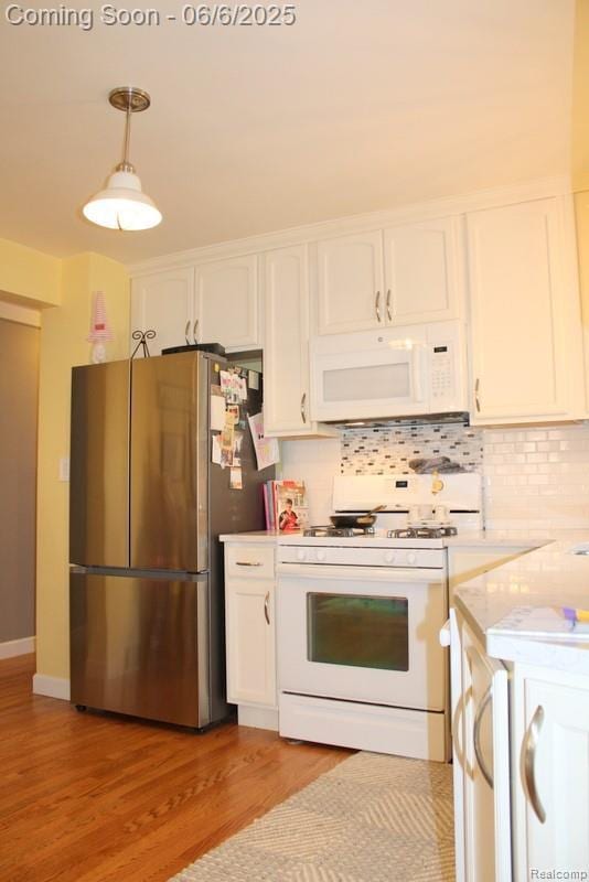3338 Maple Dr, Melvindale, MI 48122 - kitchen with white appliances, white cabinets, light wood-style flooring, backsplash, and decorative light fixtures