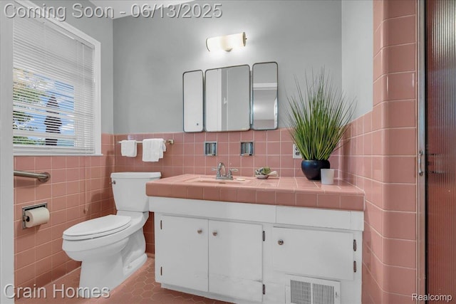 6151 Golfview Dr, Bloomfield Hills, MI 48301 - bathroom with vanity, toilet, tile walls, wainscoting, and tile patterned floors