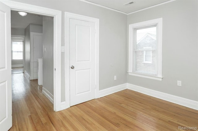 3485 Bedford St, Detroit, MI 48224 - unfurnished bedroom with light wood-style flooring, crown molding, and multiple windows