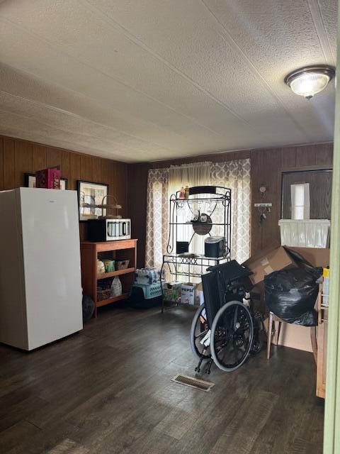 583 S Mcintosh Ln, Muskegon, MI 49442 - dining area featuring wood finished floors, wooden walls, and a textured ceiling