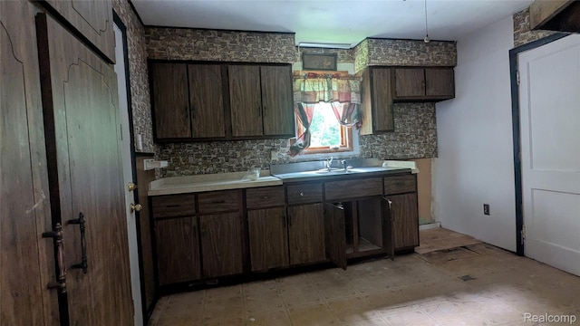 551 Nebraska Ave, Pontiac, MI 48341 - kitchen with backsplash, light countertops, a sink, and dark brown cabinetry