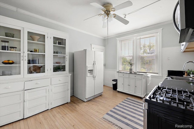 2160 Concord St, Detroit, MI 48207 - kitchen with white fridge with ice dispenser, stainless steel microwave, a ceiling fan, range with gas cooktop, and light wood-style flooring