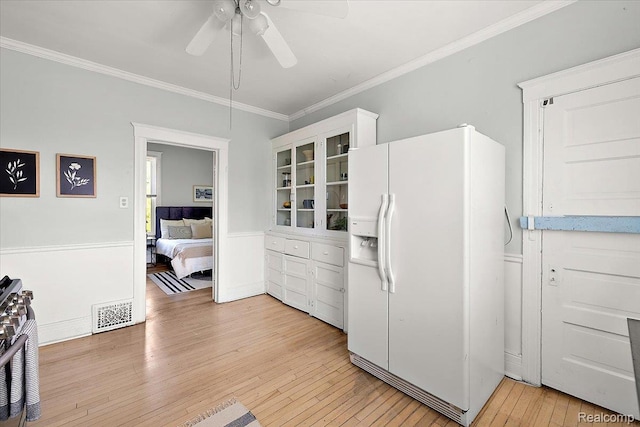 2160 Concord St, Detroit, MI 48207 - kitchen featuring white refrigerator with ice dispenser, ceiling fan, light wood-style floors, ornamental molding, and stainless steel gas range