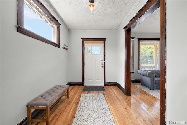 2160 Concord St, Detroit, MI 48207 - foyer entrance featuring healthy amount of natural light, light wood-type flooring, ornamental molding, and a textured ceiling