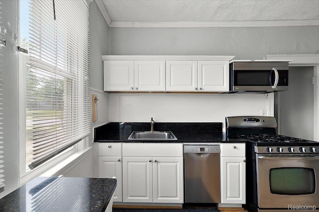 2160 Concord St, Detroit, MI 48207 - kitchen with stainless steel appliances, crown molding, dark countertops, and white cabinets