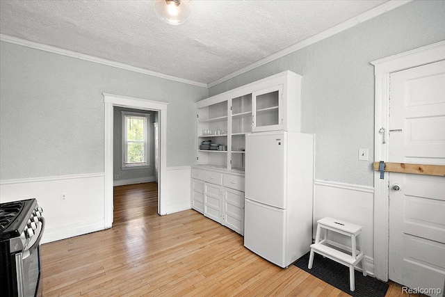 2160 Concord St, Detroit, MI 48207 - kitchen with fridge, gas stove, a textured ceiling, crown molding, and light wood finished floors