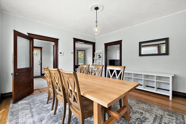 2160 Concord St, Detroit, MI 48207 - dining room featuring wood finished floors, a textured ceiling, and crown molding