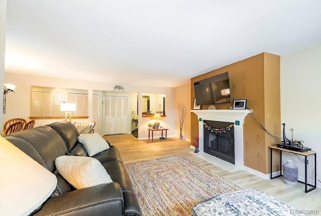 8597 Mathias Dr # 37, Grosse Ile, MI 48138 - living room featuring wood finished floors, a fireplace with flush hearth, and baseboards