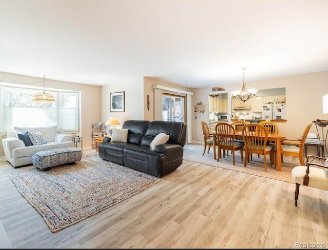 8597 Mathias Dr # 37, Grosse Ile, MI 48138 - living area featuring a chandelier, light wood-type flooring, healthy amount of natural light, and baseboards