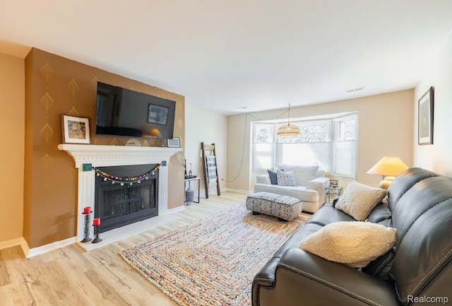 8597 Mathias Dr # 37, Grosse Ile, MI 48138 - living area featuring wood finished floors, a fireplace with flush hearth, and baseboards