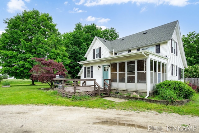 6810 Pierce St, Allendale, MI 49401 - view of front facade featuring roof with shingles, a wooden deck, a sunroom, and a front yard