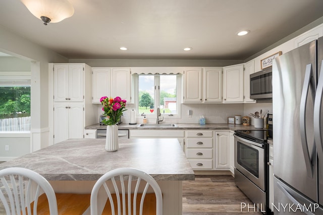 6810 Pierce St, Allendale, MI 49401 - kitchen with appliances with stainless steel finishes, a sink, a breakfast bar area, white cabinetry, and recessed lighting